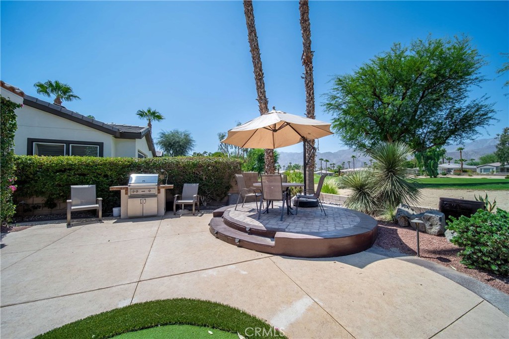 81955 Golden Star Way La Quinta, CA 92253 - Photo 48 of 54 a patio with a table and chairs under an umbrella