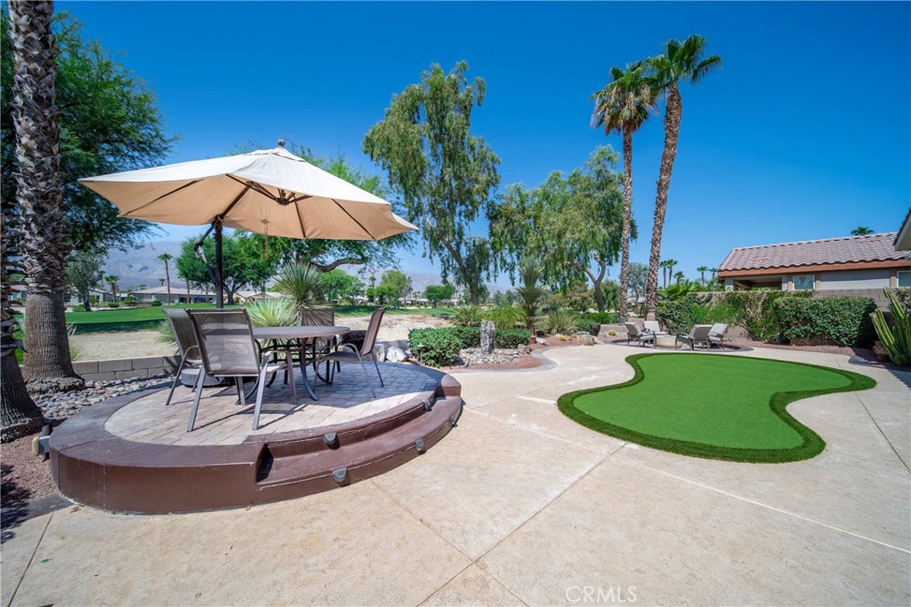 81955 Golden Star Way La Quinta, CA 92253 - Photo 51 of 54 a view of a swimming pool with a table and chairs under an umbrella