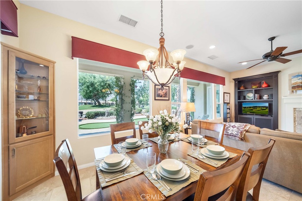81955 Golden Star Way La Quinta, CA 92253 - Photo 7 of 54 a dining room with furniture a large window and a chandelier