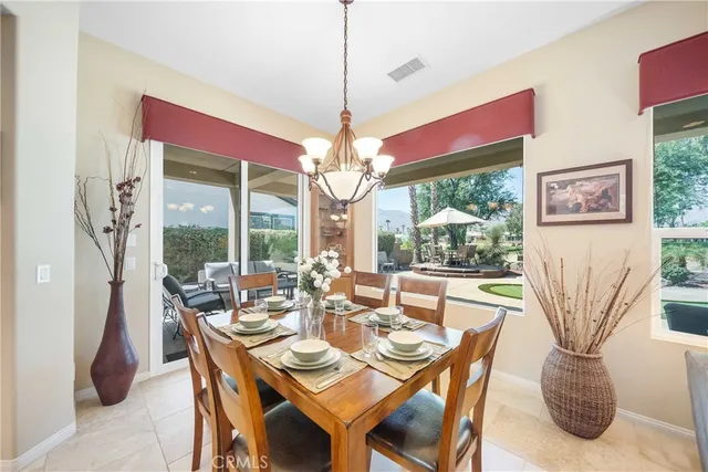 a dining room with furniture large windows and a chandelier