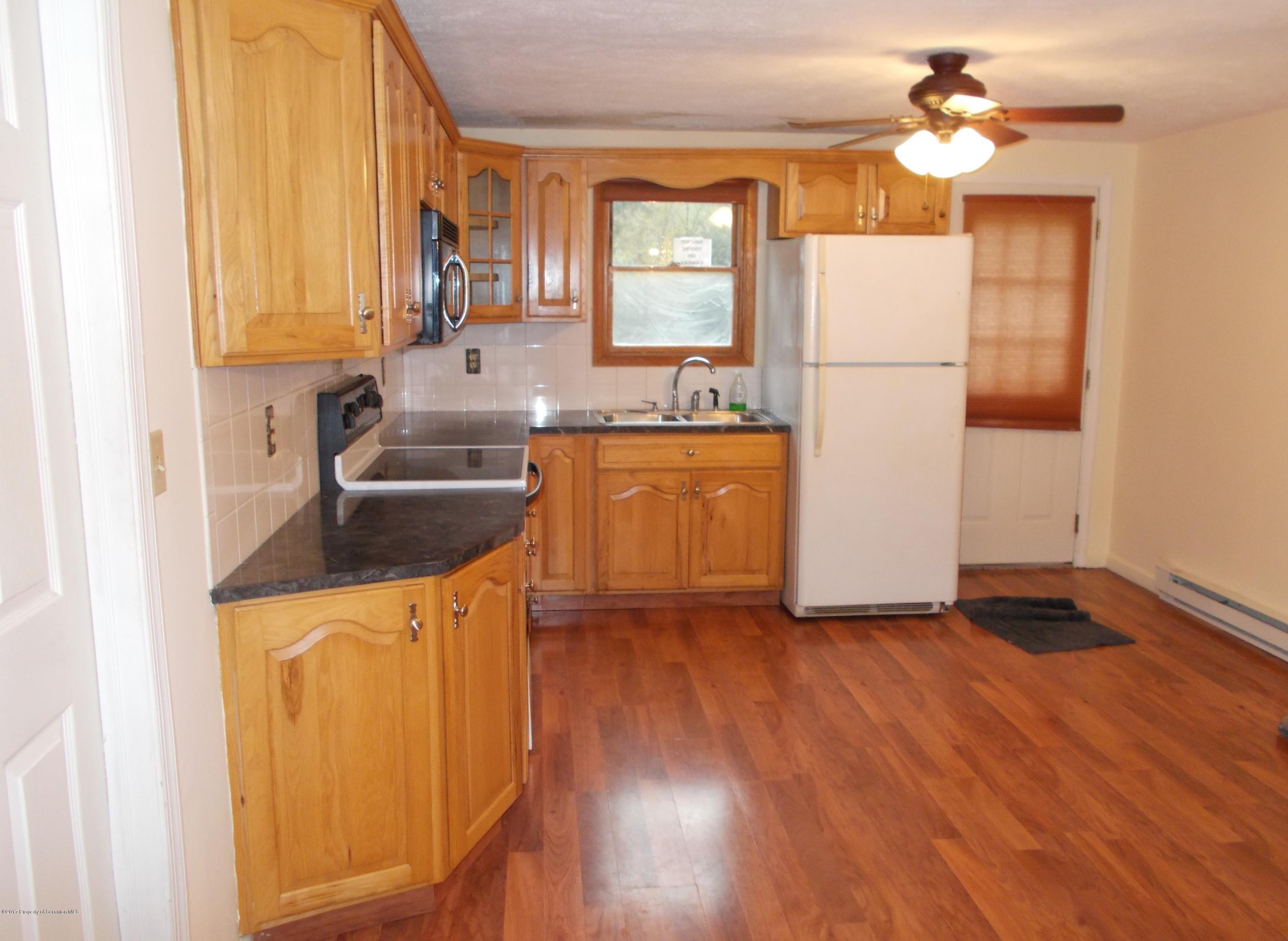 6 Watrees Rd Spring Brook Springfield, NJ 07081 - Photo 3 of 23 a kitchen with granite countertop a refrigerator a sink dishwasher a stove and white countertops with wooden floor