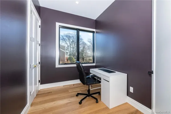 a view of a workspace with furniture and a window