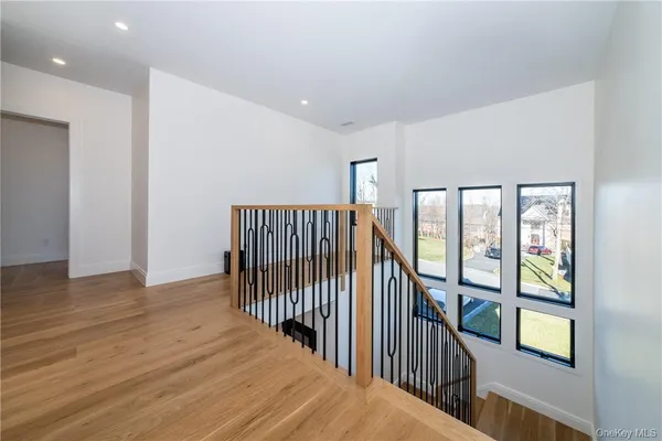 a view of a hallway with wooden floor and windows