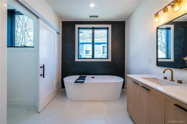 a spacious bathroom with a bathtub and 2 sink