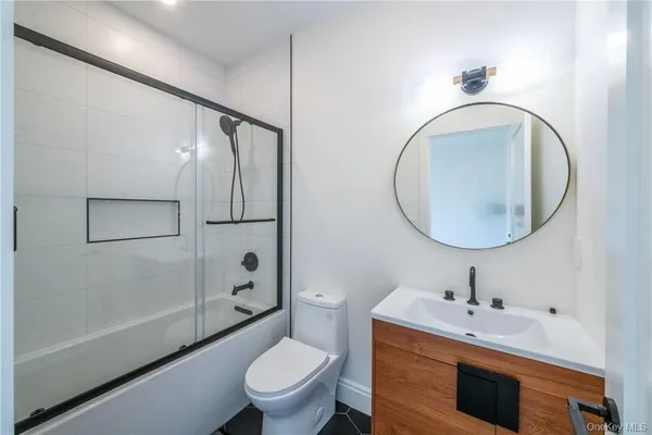 a bathroom with a toilet a sink a mirror and a shower