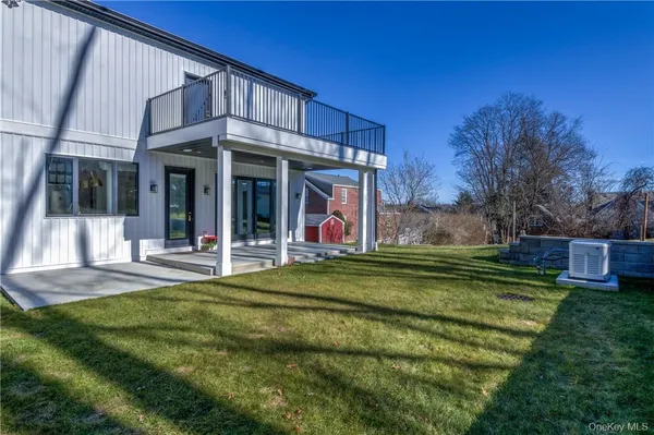 a view of a house with a yard porch and wooden fence