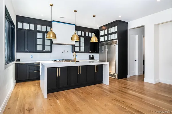 a kitchen with stainless steel appliances kitchen island granite countertop a refrigerator and a sink