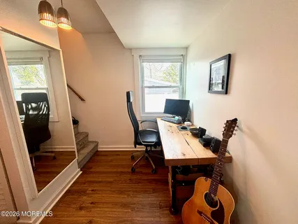 a view of a workspace with furniture and a window