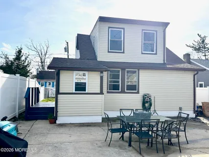 a view of a house with a patio and a yard