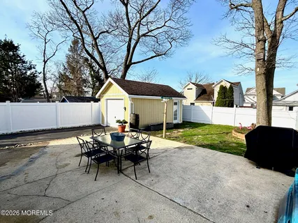 a view of a house with backyard and a tree