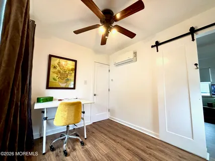 a workspace room with wooden floor and windows