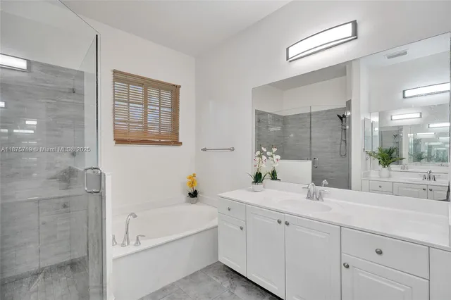 a room with a white tub flowerpot and mirror