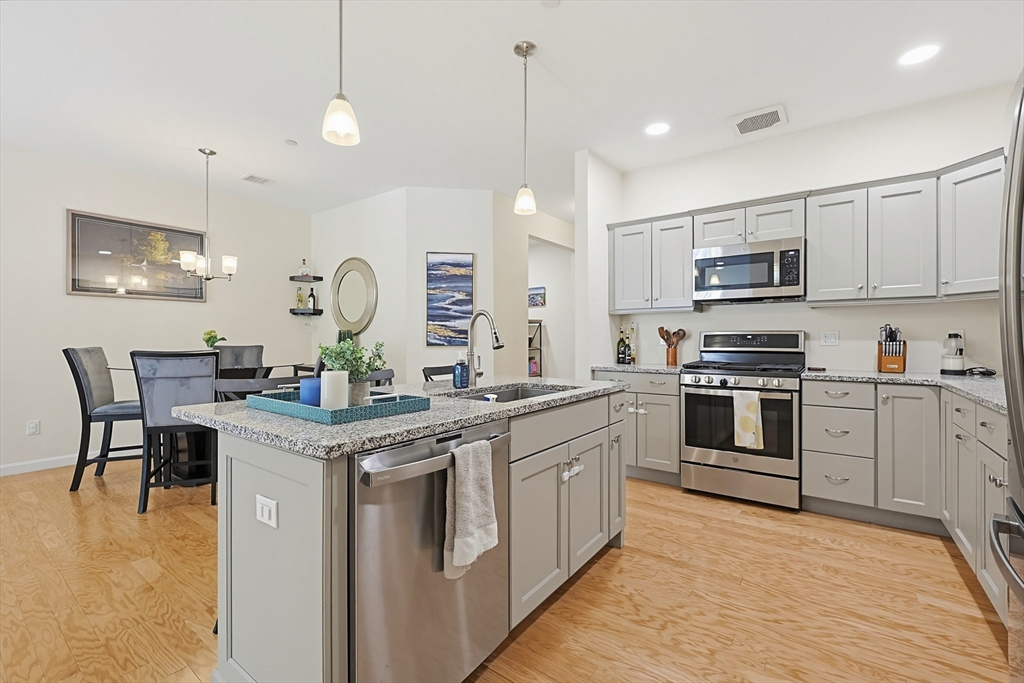 200 Revere Street, Unit 4209 Canton, MA 02021 - Photo 9 of 35 a kitchen with stainless steel appliances granite countertop a stove a sink and a refrigerator
