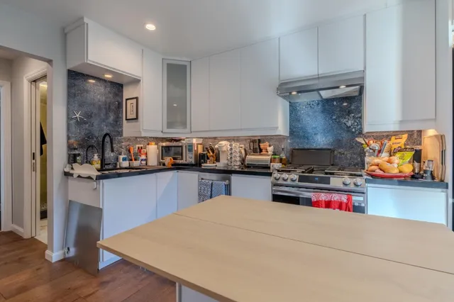 a kitchen with stainless steel appliances granite countertop a stove and a refrigerator
