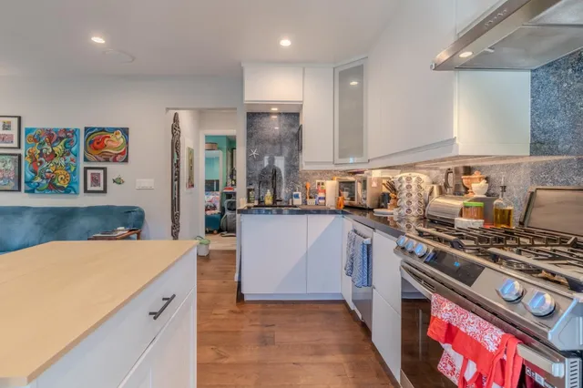 a kitchen with stainless steel appliances granite countertop a stove a sink and a refrigerator