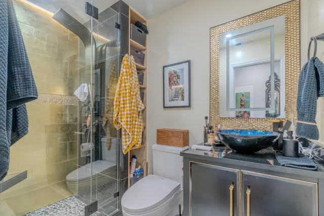 a bathroom with a sink a toilet and shower