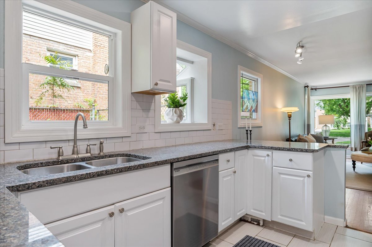 630 Long Road Glenview, IL 60025 - Photo 7 of 24 a kitchen with granite countertop a sink white cabinets and white stainless steel appliances