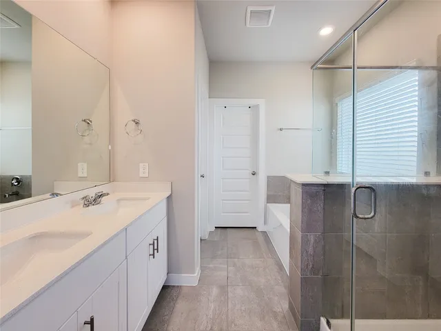 a bedroom with a bed and a large mirror on the dresser