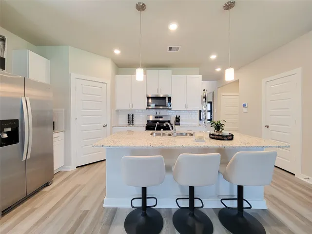 a kitchen with granite countertop sink stove and refrigerator