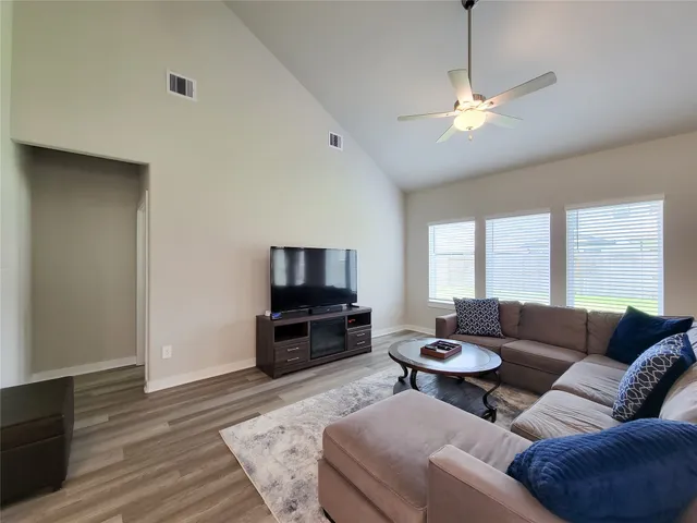 a living room with furniture and a table with wooden floor