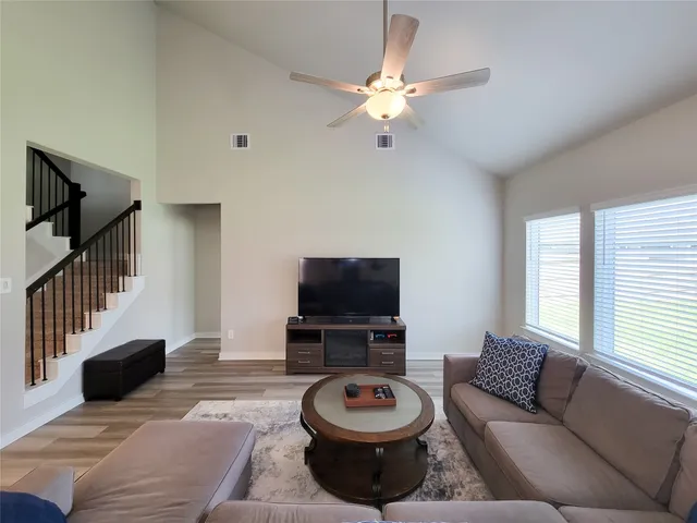 a living room with furniture and wooden floor