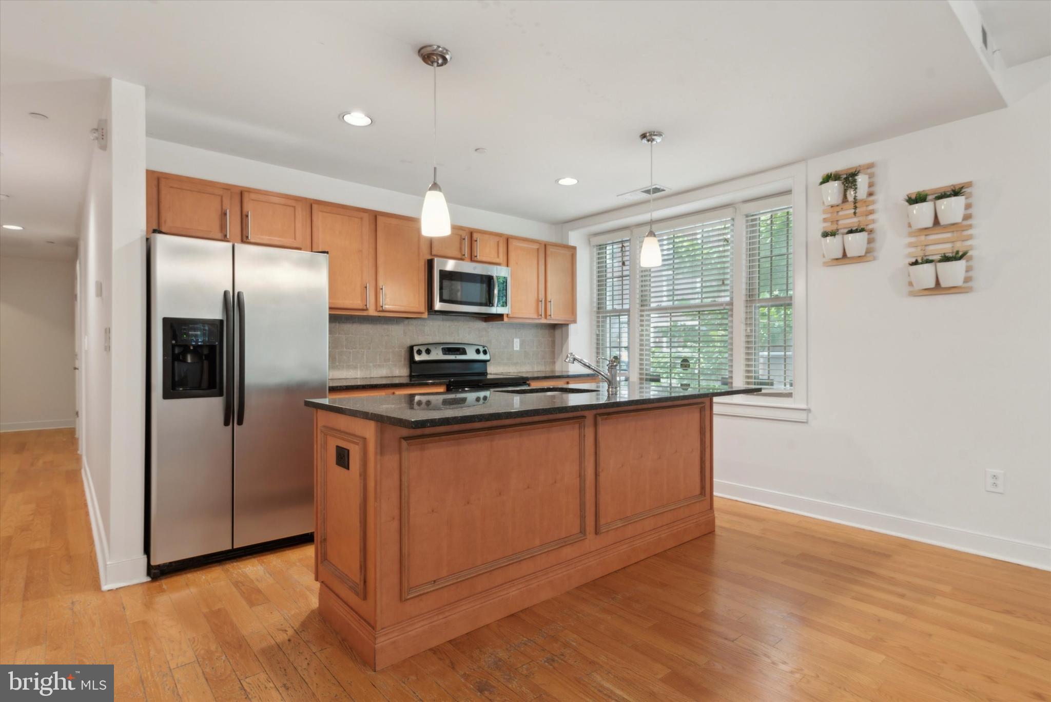 4300 Spruce Street, Unit A101 Philadelphia, PA 19104 - Photo 11 of 25 a kitchen with stainless steel appliances granite countertop a refrigerator a stove a sink and a microwave