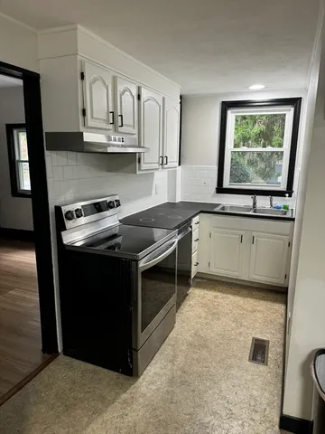 a kitchen with granite countertop white cabinets and white appliances
