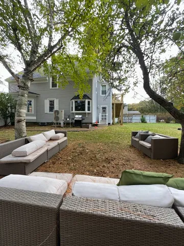 a view of a house with backyard and sitting area