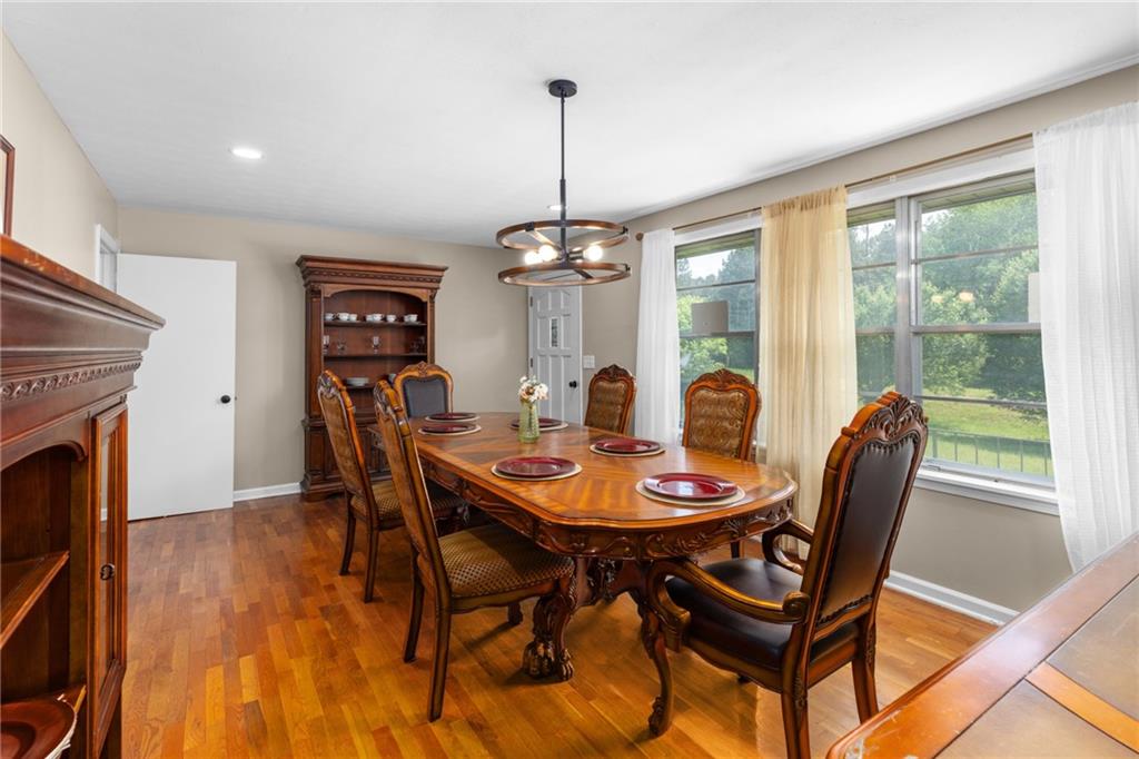7596 Red Bud Road Northeast Ranger, GA 30734 - Photo 26 of 47 a dining room with furniture a floor to ceiling window and wooden floor