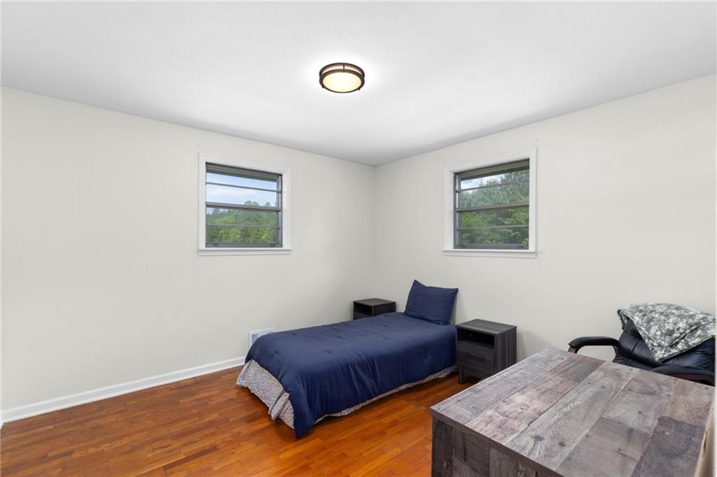 7596 Red Bud Road Northeast Ranger, GA 30734 - Photo 36 of 47 a bedroom with two beds and a lamp next to a window