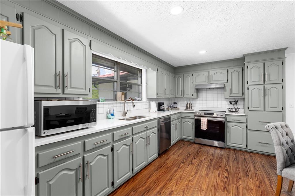 7596 Red Bud Road Northeast Ranger, GA 30734 - Photo 42 of 47 a kitchen with stainless steel appliances granite countertop a stove a sink dishwasher and a refrigerator with wooden floor