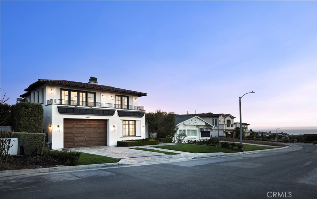 a front view of a house with a garden and mountain view