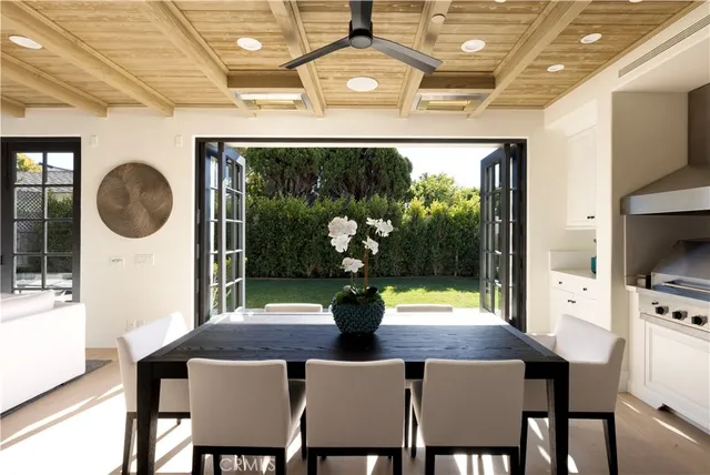 a dining room with furniture a floor to ceiling window and wooden floor
