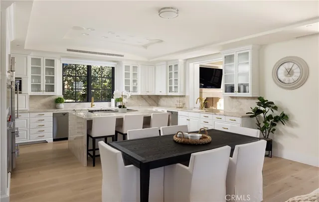 a kitchen with a table chairs sink and cabinets