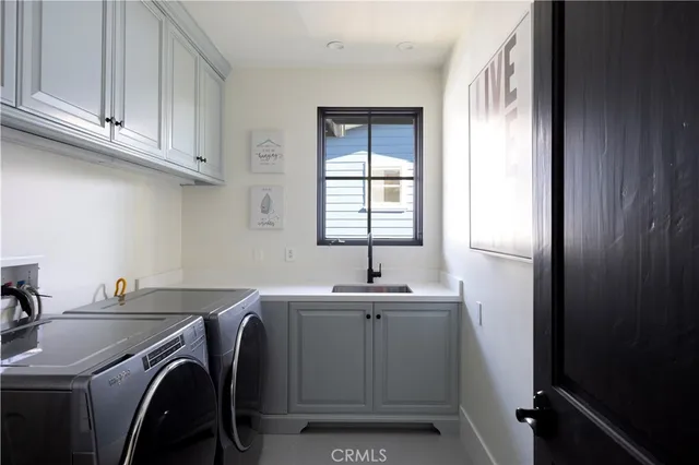 a utility room with sink dryer and washer