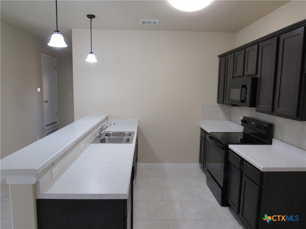 1108 Stealth Lane, Unit A Killeen, TX 76549 - Photo 6 of 21 a kitchen that has a sink and a stove in it