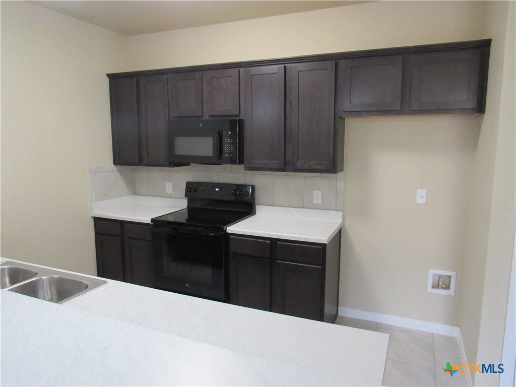 1108 Stealth Lane, Unit A Killeen, TX 76549 - Photo 7 of 21 a kitchen with a refrigerator and a stove top oven