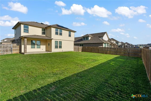 a view of a house with a big yard and large trees