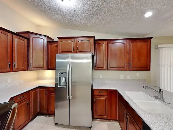 a kitchen with stainless steel appliances granite countertop a refrigerator and a sink