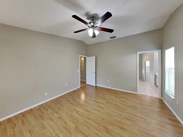 a view of an empty room with wooden floor