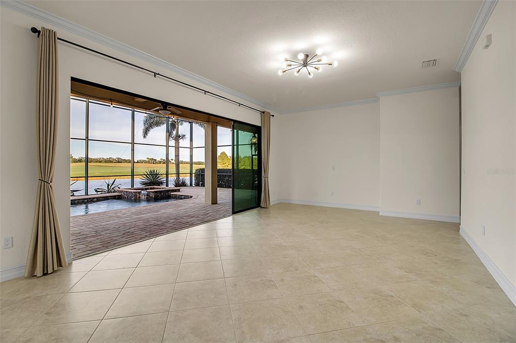 5609 Arnie Loop Lakewood Ranch, FL 34211 - Photo 13 of 64 an empty room with floor to ceiling windows and pool table