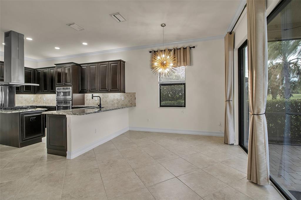 5609 Arnie Loop Lakewood Ranch, FL 34211 - Photo 15 of 64 a kitchen with stainless steel appliances granite countertop a stove a sink and a refrigerator