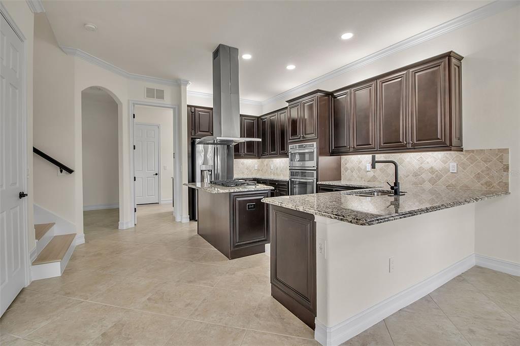 5609 Arnie Loop Lakewood Ranch, FL 34211 - Photo 16 of 64 a kitchen with stainless steel appliances granite countertop a sink stove and refrigerator