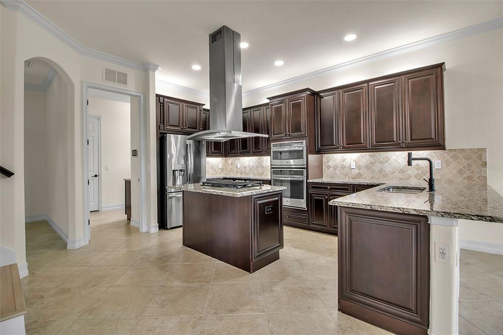 5609 Arnie Loop Lakewood Ranch, FL 34211 - Photo 17 of 64 a kitchen with stainless steel appliances granite countertop a refrigerator a stove and a sink