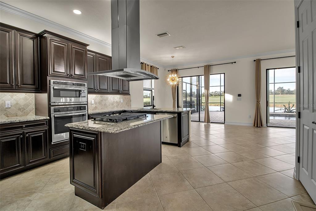 5609 Arnie Loop Lakewood Ranch, FL 34211 - Photo 18 of 64 a kitchen with granite countertop a stove top oven and cabinets