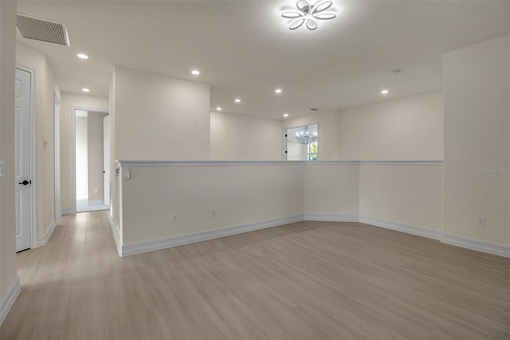 5609 Arnie Loop Lakewood Ranch, FL 34211 - Photo 31 of 64 an empty room with wooden floor and windows