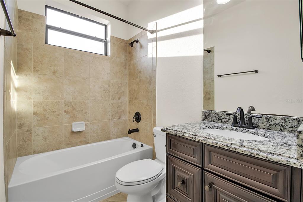 5609 Arnie Loop Lakewood Ranch, FL 34211 - Photo 37 of 64 a bathroom with a granite countertop bathtub shower sink vanity mirror and toilet