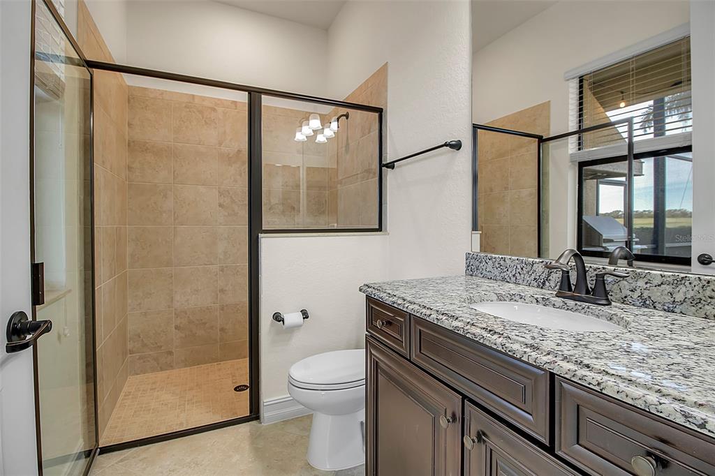 5609 Arnie Loop Lakewood Ranch, FL 34211 - Photo 49 of 64 a bathroom with a granite countertop sink a mirror and shower