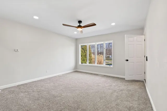 an empty room with windows and fan