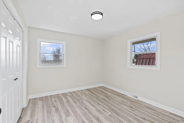 a view of empty room with wooden floor